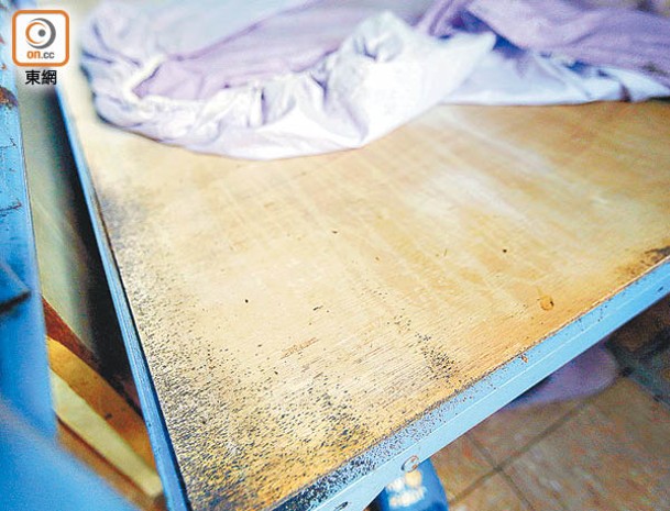 床板及床單上有為數不少的床蝨及蝨卵，木板部分被染成黑色。