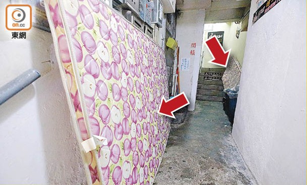 荃灣：沙咀道有舊樓被人棄置兩張床褥（箭嘴示）在梯間。