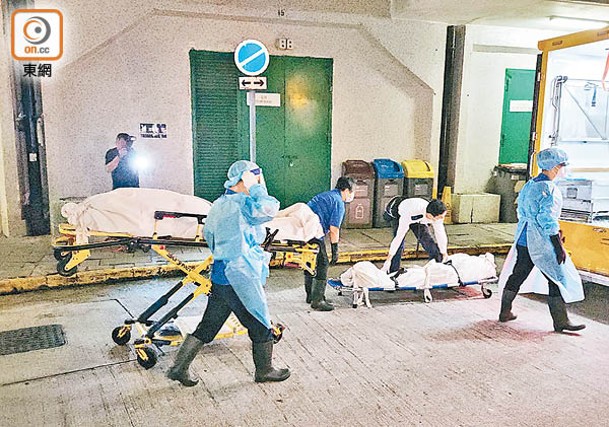 食環署職員將兩名德田邨死者遺體舁送殮房。
