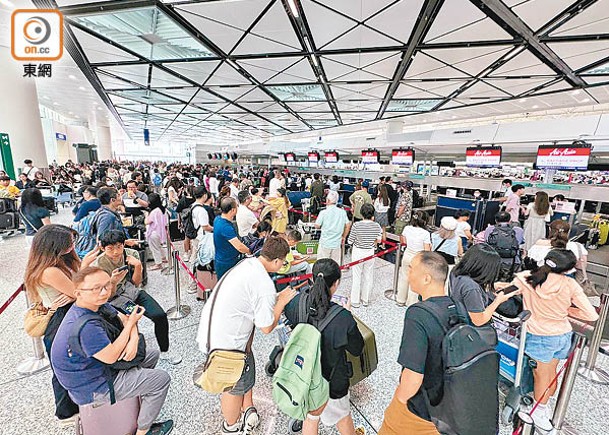 亞洲航空機場櫃位有近百人「打蛇餅」排隊。（陳俊華攝）