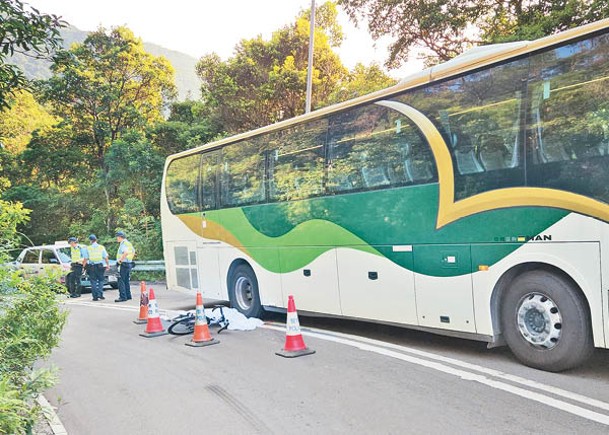 女事主躺臥旅遊巴旁邊，所踩的單車也在一旁。