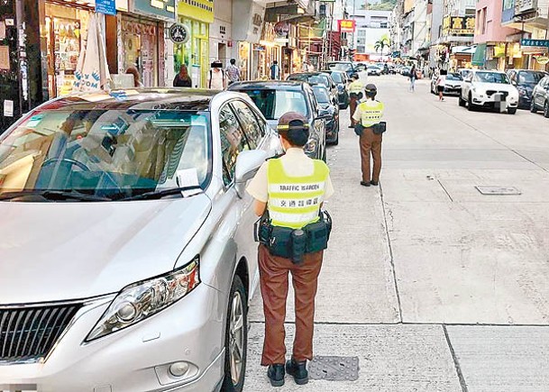 西九：交通督導員向違泊的車輛發出告票。