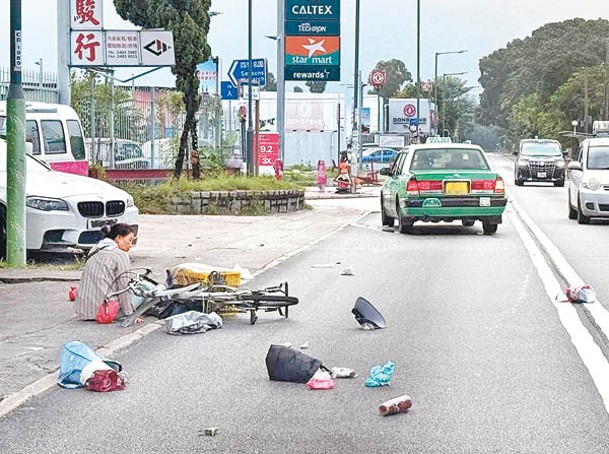 錦田：捱撞婦人坐地待援，雜物散落地上。