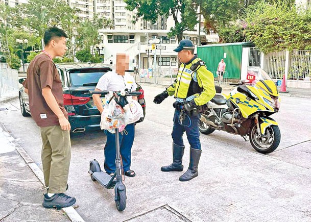 涉嫌違規駕駛電動滑板車的男子（中）被捕。