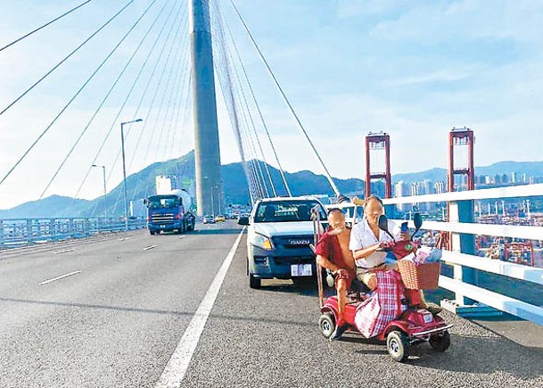 載乘兩男的電動車停在路肩，後方有一輛私家車。