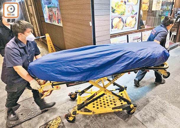 死者遺體舁送殮房。（文健雄攝）