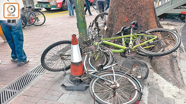 多輛單車違例泊在大樹旁，部分被推跌落地。