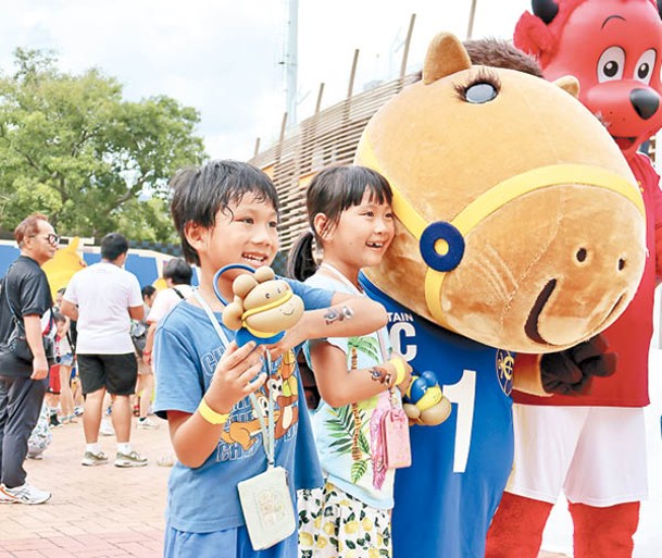 市民拿着各式道具與馬會及曼聯吉祥物合照。