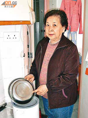 莫婆婆以碟子充當飯煲蓋，手部不時險被燙傷。