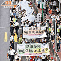 本港有民眾高舉抗議標語遊行。	（高嘉業攝）