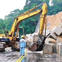 台北縣出動重型儀器逐一移走掉在路邊的水泥石塊。	（本報台北傳真）