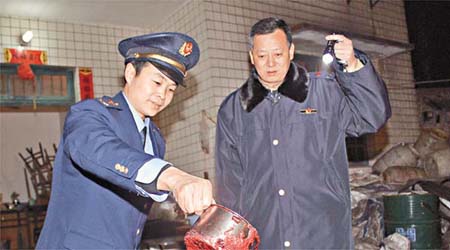 重慶執法人員查看製作豬血膏的原料。	（中新社圖片）