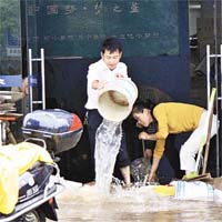 江西瑞昌市的商戶在清理積水。	（中新社圖片）