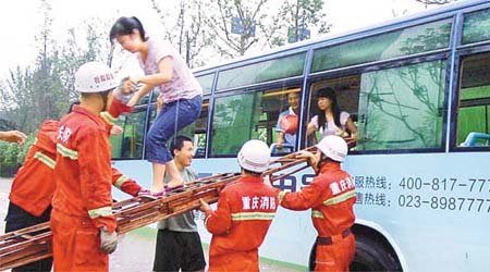 重慶消防員拯救被洪水圍困的巴士乘客。	（中新社圖片）