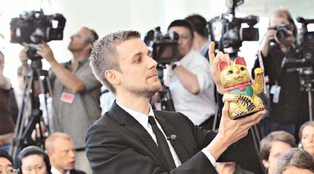 德國一名電視台記者向溫家寶送上招財貓。	（Getty Image圖片）