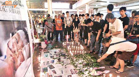 社民連昨晚在旺角東火車站外為溫州高鐵慘劇的死難者舉行悼念活動。	（羅錦鴻攝）