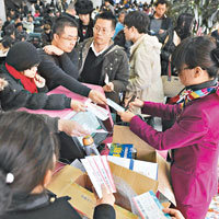 大量赴京航班取消，杭州蕭山機場工作人員向滯留旅客派發食物。（中新社圖片）