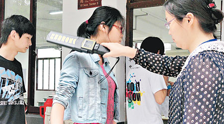 蘇州考生進入考場前接受金屬探測器檢查。（中新社圖片）