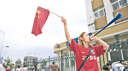 丹東市有球迷在庭外吹氣笛為中國足球加油。（中新社圖片）