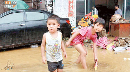 深圳橫崗馬六村水浸，小孩如常玩耍。（本報深圳傳真）