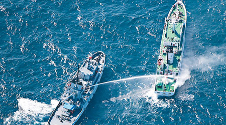海軍救援船隻模擬為海監船隻射水「滅火」。（中新社圖片）