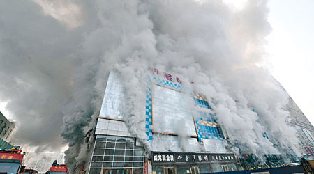 哈爾濱一家商場昨早發生火災，現場濃煙滾滾。（中新社圖片）