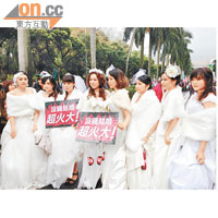 遊行人士打扮成新娘，手持抗議標語。（張孝義攝）