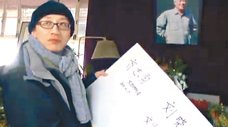 胡佳在紀念冊上簽上劉曉波夫婦的名字。（有線畫面）