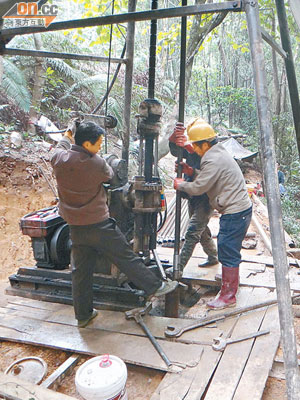 現場礦工操作探土機挖取礦石。（本報河源傳真）