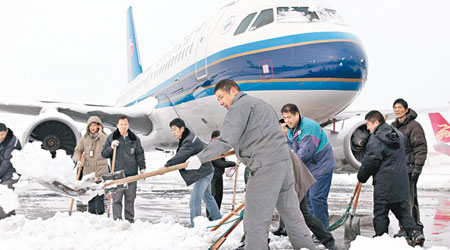 南京祿口機場派員剷雪除冰。（中新社圖片）