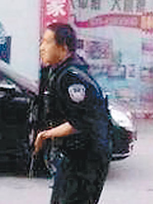 新疆街頭有警員持槍戒備。