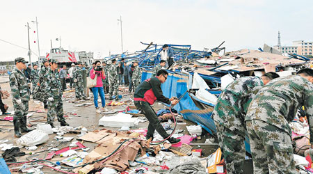湖南<br>道縣遭龍捲風吹襲後，救援人員在街頭清理雜物。（中新社圖片）