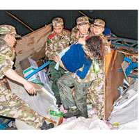湖南<br>道縣救援官兵從倒塌的房屋中救出一名被困婦女。（中新社圖片）