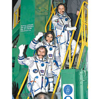 三名太空人登上聯盟號前，向群眾揮手致意。（Getty images圖片）