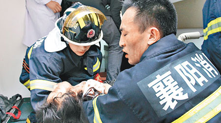 消防員救出一名小童。（中新社圖片）