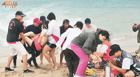 救援人員在沙灘上為多名遇溺泳手進行急救。（本報屏東傳真）