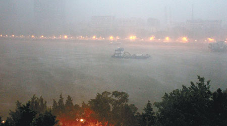 廣州珠江上有船隻在風雨中前行。（中新社圖片）