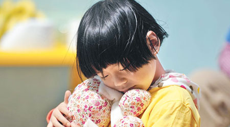 昆明一名女童抱着布玩偶，愛不釋手。（中新社圖片）