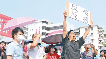 民眾高舉抗議標語反核。（中新社圖片）