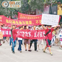 示威者舉起橫額遊行至市政府抗議。（讀者提供）