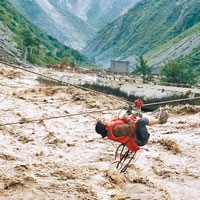 汶川有婦女被洪水圍困，武警出動空中鋼索將其救出。（中新社圖片）