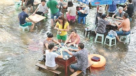 重慶民眾在水中打牌消暑。（中新社圖片）