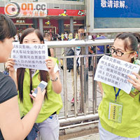 一批志願者在火車站外舉起紙牌，告知持票人士可於五日內退票。（張琦攝）