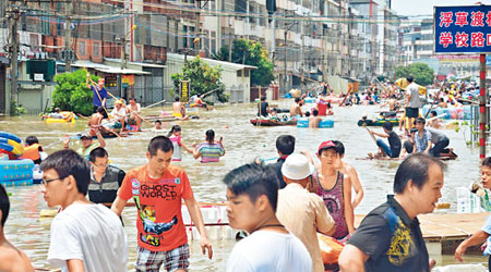 汕頭市潮南地區不少道路被水淹浸，市民於大街划船。（中新社圖片）