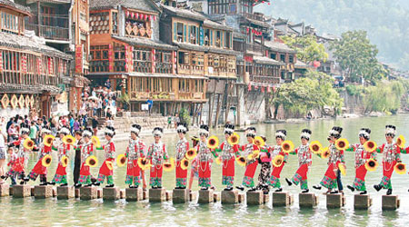 湖南鳳凰古城一批穿着傳統服飾的苗家女士迎客。（中新社圖片）
