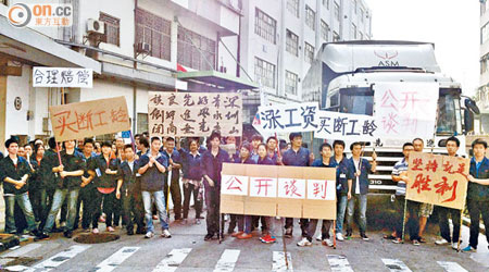 罷工工人舉起標語要求與資方談判。（兩岸組記者深圳傳真）
