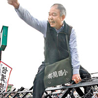 自稱是台灣民族黨主席的男子，企圖跨過圍欄闖入管制區，其後遭警方帶走。（中央社圖片）
