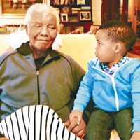 曼德拉今年五月與曾孫在約翰內斯堡家中手牽手合照，相信是他生前最後一張已公開的照片。（互聯網圖片）