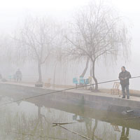 湖南長沙縣黃雲鎮數名市民在霧霾天氣下垂釣。（中新社圖片）