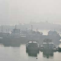 海口<br>海南海口新港碼頭的漁船於霧霾籠罩下猶如水墨畫。（中新社圖片）